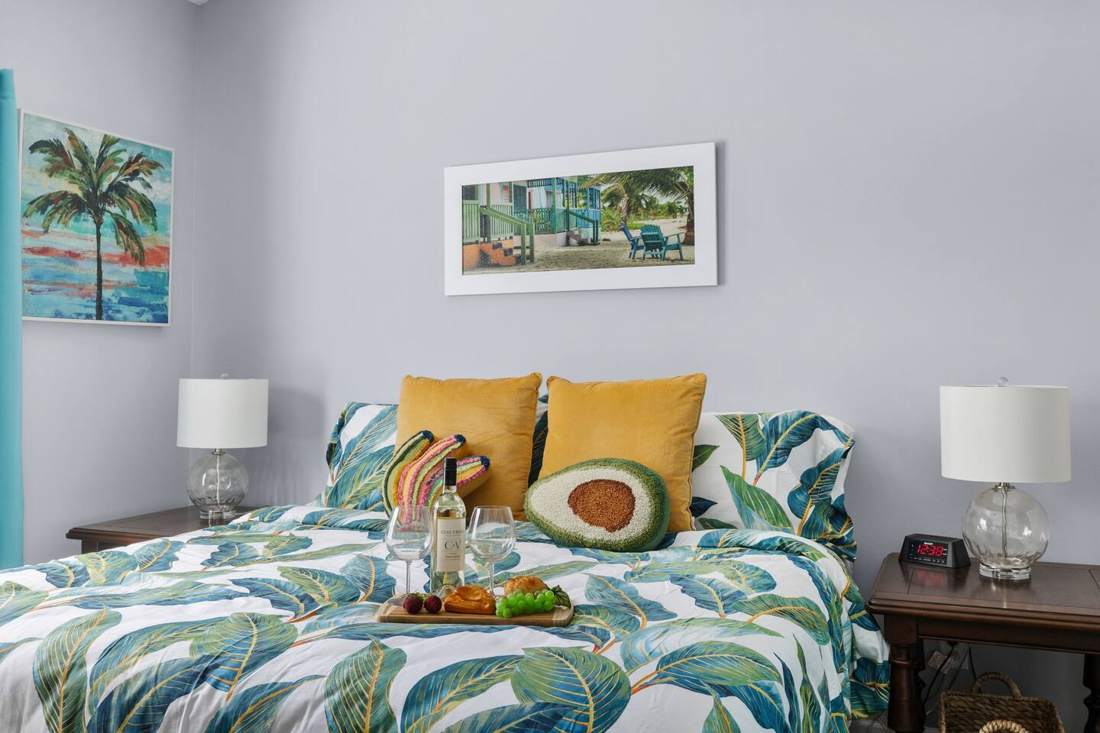 Primary bedroom with a king bed and tropical-print bedding